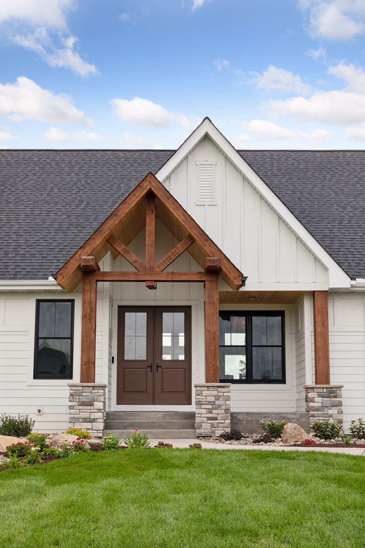 Double-gabled front entry with stained wood accents and stone details