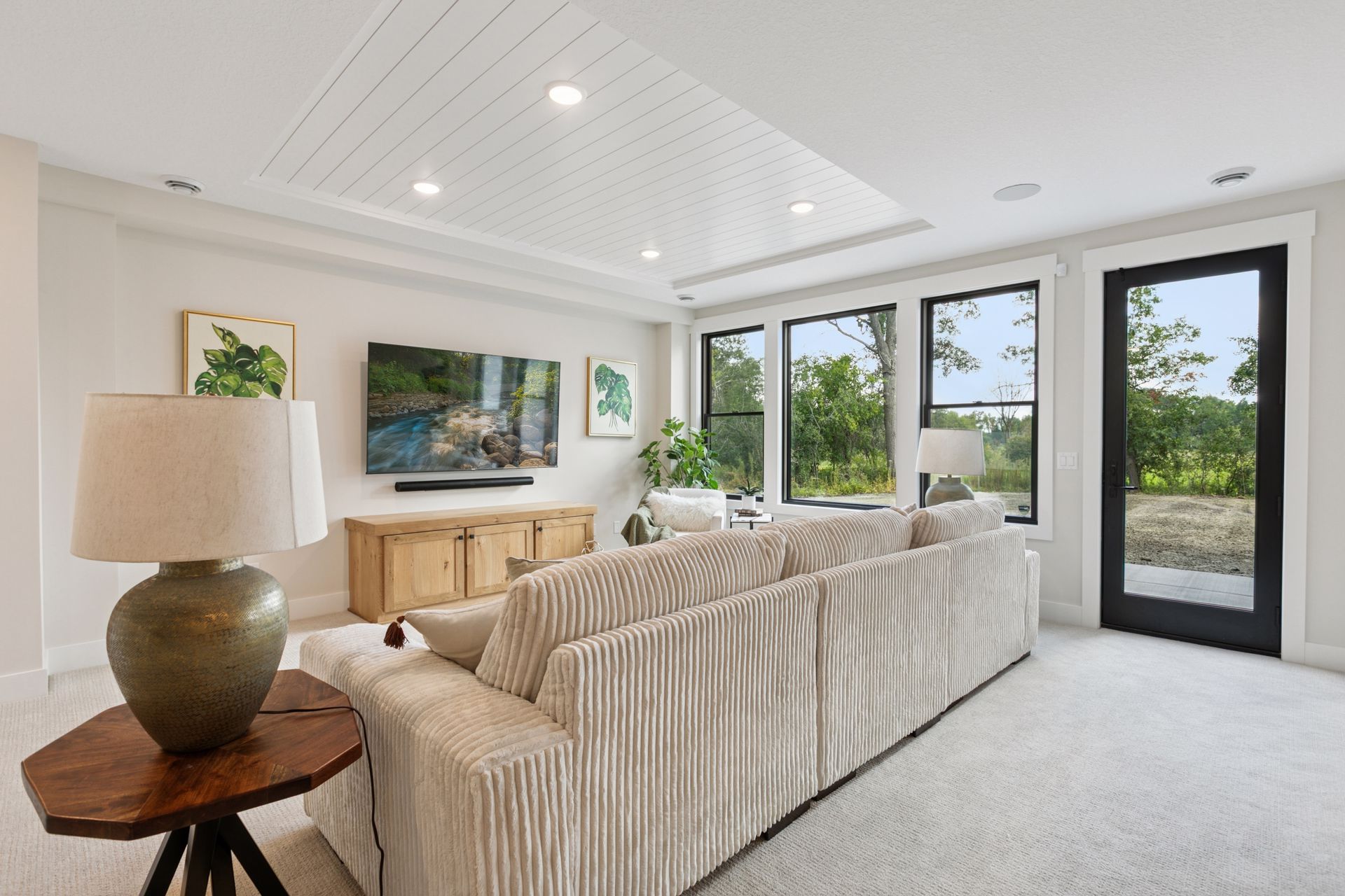 Rec room with large windows showcasing wooded outdoor views