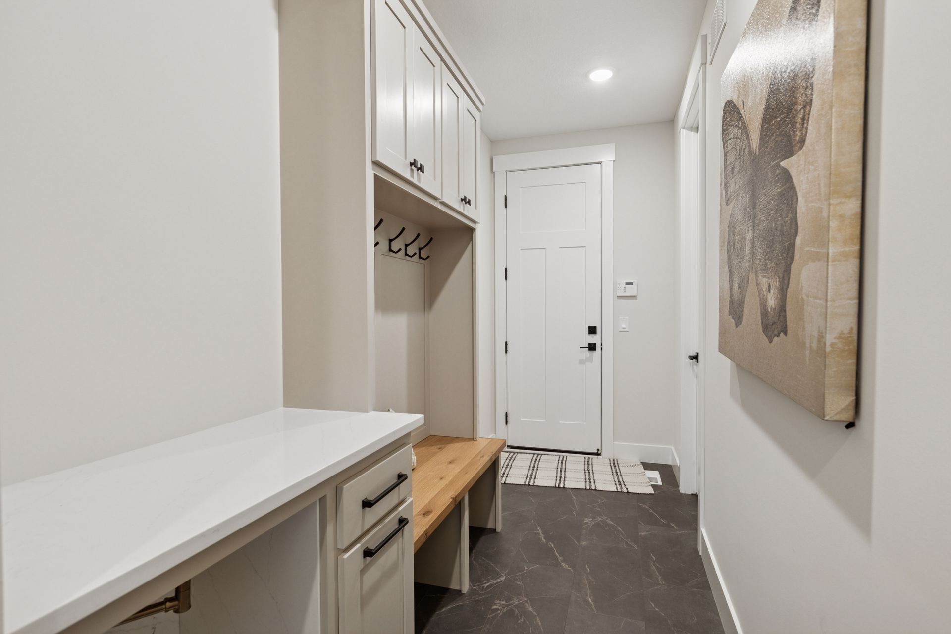 Functional mudroom featuring custom bench seating, storage cubbies, and coat hook